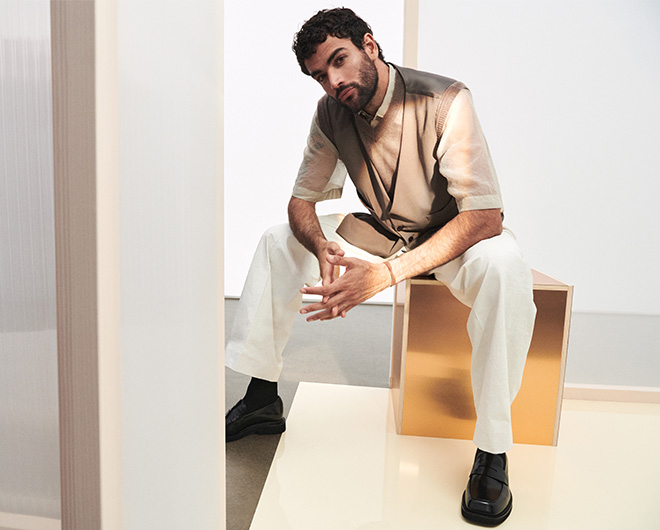 Matteo Berrettini sitting on a golden box and posing in front of a white background (photo)