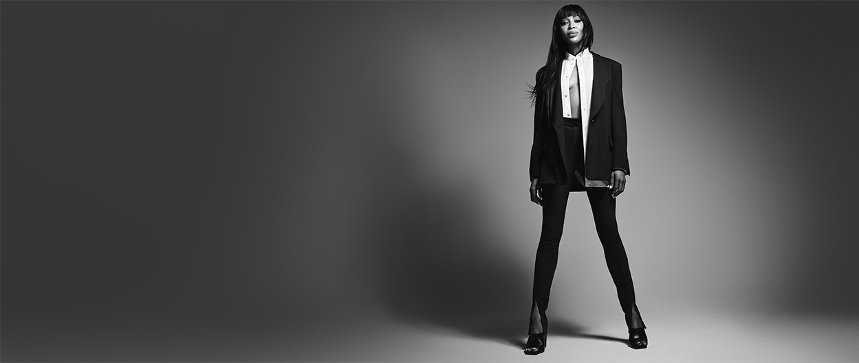 Naomi Campbell posing in front of a white background; the picture has a black and white effect (photo)