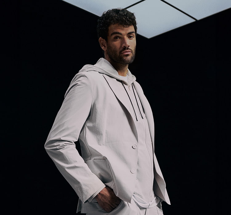 BOSS Performance – Matteo Berrettini dressed in white, posing in front of a black background (photo)